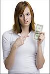 Portrait of a young woman holding an American one dollar bill