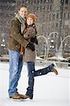 Couple embracing outdoors in winter with ice skates