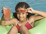 Portrait d'une jeune fille sur le flotteur dans une piscine