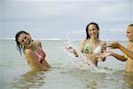 Drei Mädchen im Teenageralter Spritzwasser im Meer
