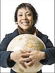 Portrait of a young woman holding a globe