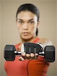 Portrait of a young woman exercising with a dumbbell