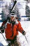 Man with skis and poles outdoors in winter