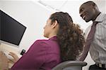 Low angle view of a businessman and a businesswoman looking at a computer monitor