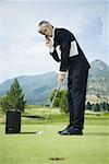 Voir le profil:: un homme d'affaires, jouer au golf et parler sur un téléphone mobile