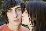 Close-up of a teenage girl kissing a teenage boy