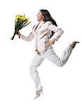 Jeune femme sautant dans les airs et tenant un bouquet de fleurs