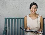 Femme d'affaires assis sur un banc et souriant