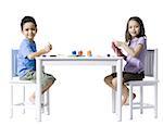 Garçon et fille assise à table, faire de l'artisanat