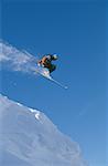 Downhill ski jumper in air