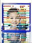 Portrait of a boy smiling behind an abacus