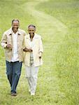 Erhöhte Ansicht ein alter Mann und einer leitenden Frau zu Fuß in ein Feld
