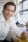 Portrait of a businessman resting his hand on the table