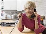 Portrait of a mature woman talking on the telephone in a kitchen