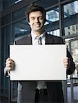 Portrait of a businessman holding a blank sign