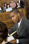 Vue grand angle sur un avocat mâle dans une salle d'audience lors d'un procès