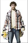 Portrait of a young man wearing a tool belt and holding a circular saw