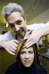 Woman having hair cut by hairdresser