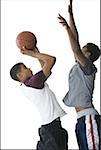 Profile of two young men playing basketball