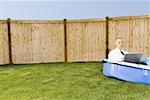 Businessman working on a laptop, sitting in a wading pool