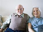Portrait d'un couple supérieur repose sur un divan et souriant