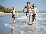 Trois jeunes garçons jouant sur la plage