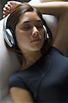 High angle view of a young woman wearing headphones with her eyes closed