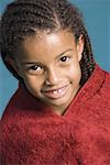 Portrait d'une jeune fille enveloppée dans une serviette et souriant