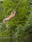 Portrait d'une jeune fille se balancer sur une corde