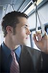 Young businessman looking through the window of a subway train