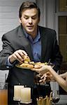 Close-up of a man choosing a spring roll from a plate