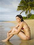 Profile of a teenage girl sitting on the beach