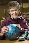 Portrait d'une femme senior tenant une boule de bowling