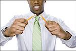 Close-up of a businessman breaking a pencil