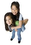 High angle view of a girl riding piggyback on a teenage girl