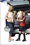 Young son helping mother with groceries