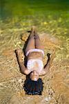 High angle view of a young woman lying in water