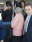 People exiting a passenger train while a woman tries to enter the train