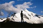 Silhouette of a man standing in front of a mountain peak