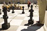 Low section view of a man playing oversized outdoor chess