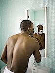 Rear view of a man shaving