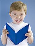 Junge lächelnd gebundenes Buch lesen