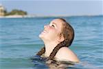 Side profile of a teenage girl smiling in the sea