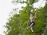 Portrait of a boy swinging on a rope