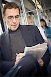 Close-up of a mature man working on a crossword puzzle in the newspaper