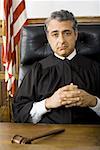 Portrait of a male judge sitting with his hands clasped