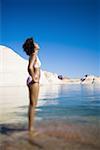 Young woman in a bikini and standing in water