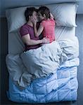 Man and woman snuggling in bed