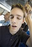 Close-up of a young man sleeping on a commuter train
