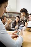 Businesswoman text messaging during a meeting